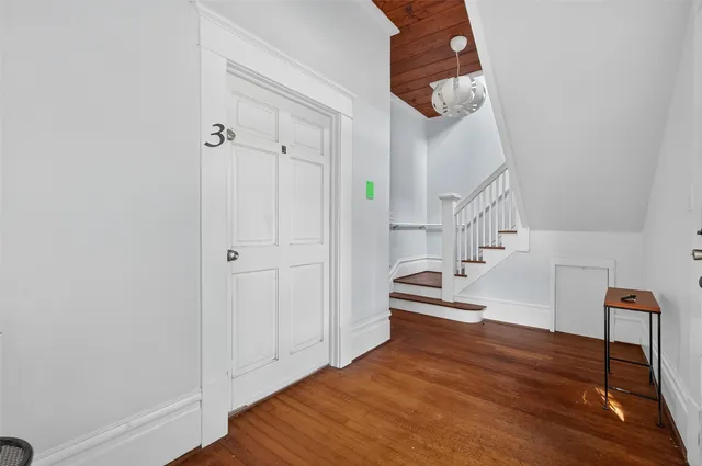 a view of entryway and hall with wooden floor