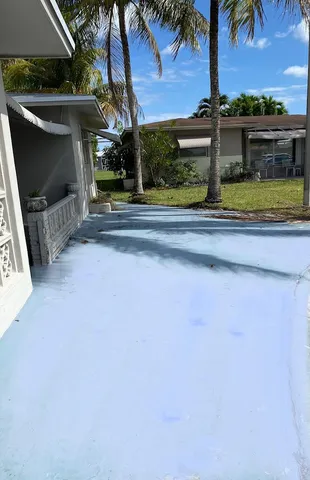a view of swimming pool with a yard and palm trees