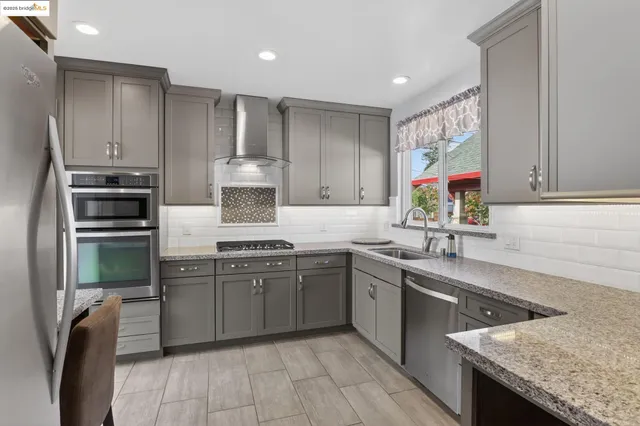 a kitchen with stainless steel appliances granite countertop a sink stove and refrigerator