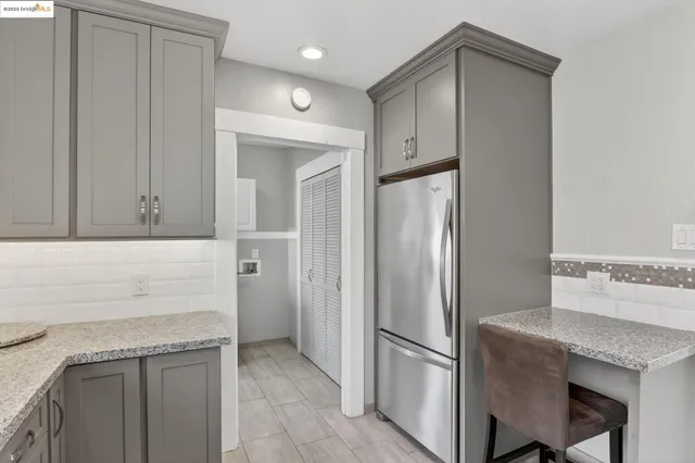 a kitchen with stainless steel appliances granite countertop a refrigerator and a stove