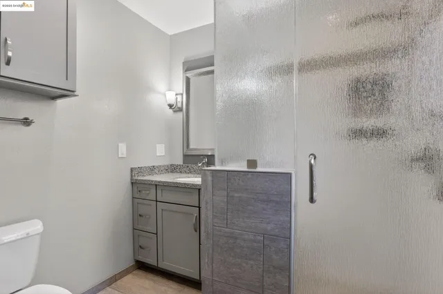 a bathroom with a granite countertop sink a toilet and a mirror