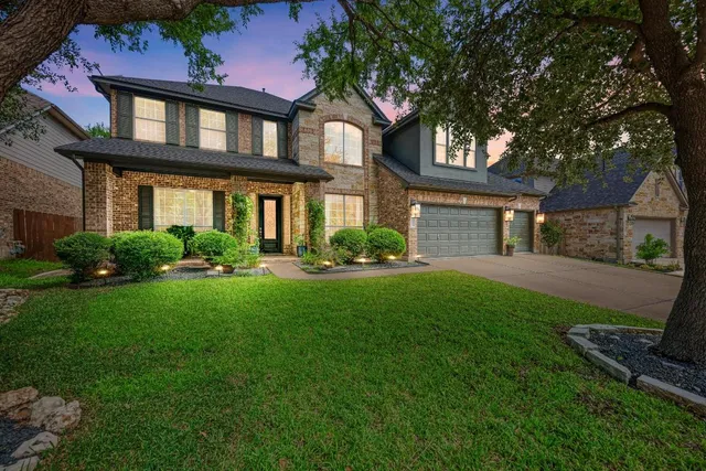 a front view of a house with a yard and potted plants