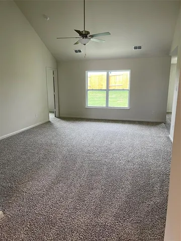 an empty room with a window and a ceiling fan