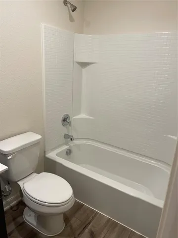 a bathroom with a toilet and a bath tub