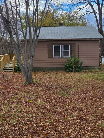 a backyard of a house with potted plants and large tree