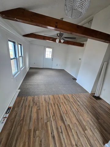 a view of a room with wooden floor and window