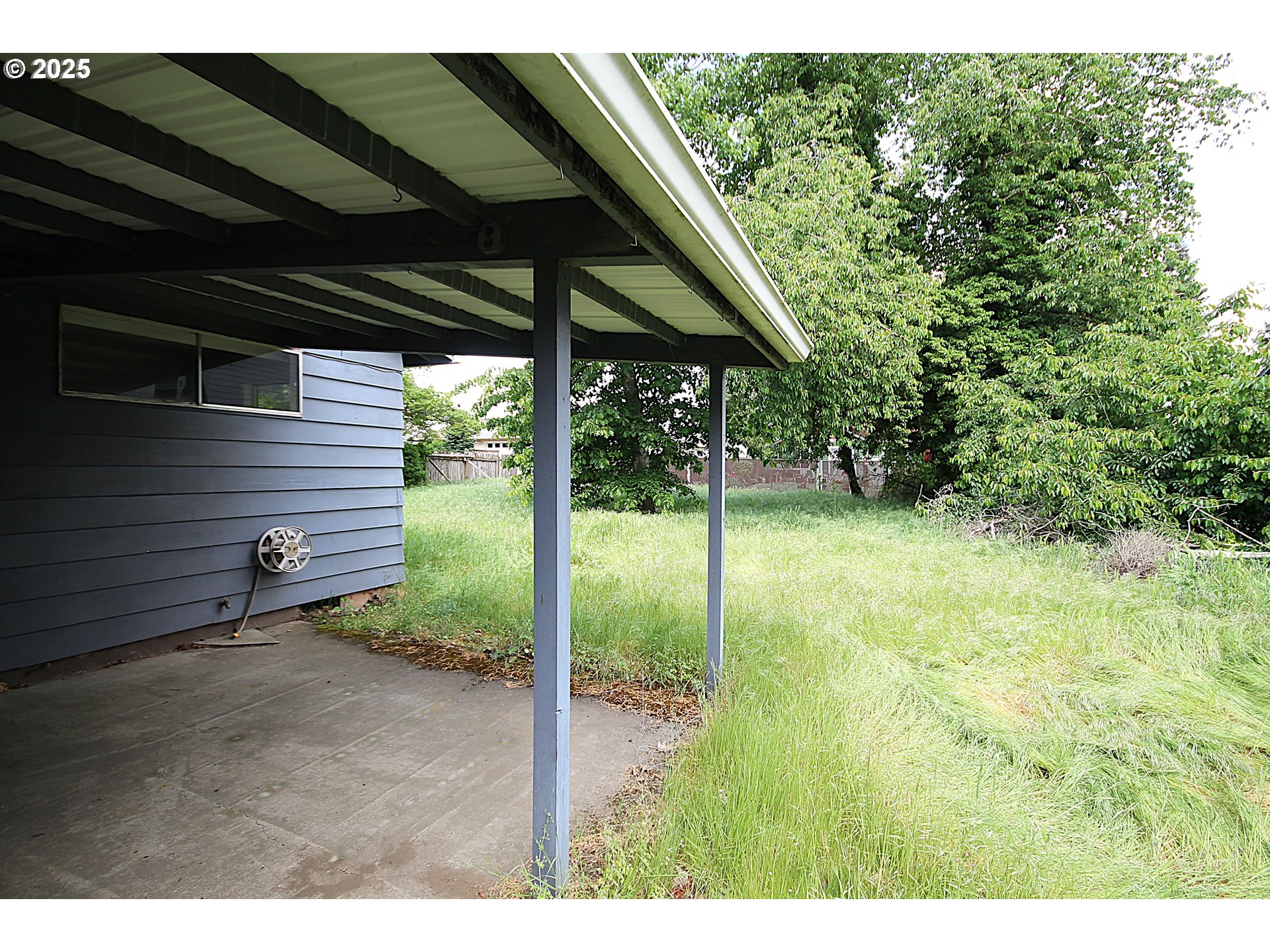 442 Northwest 4th Avenue Canby, OR 97013 - Photo 12 of 39 a backyard of a house with table and chairs under an umbrella