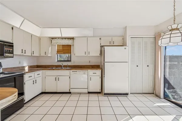 a kitchen with cabinets stainless steel appliances and a chandelier