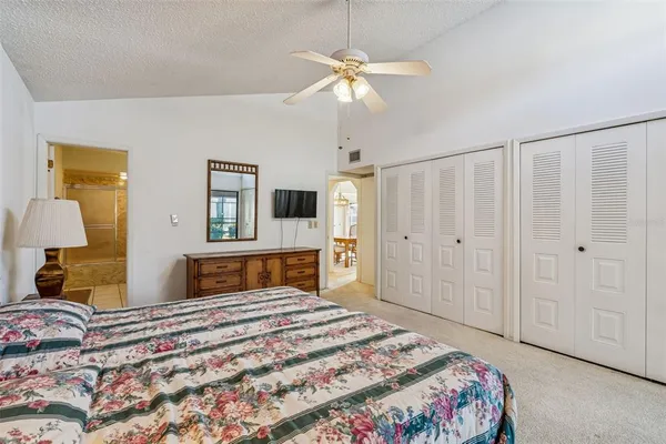 a bedroom that has a bed and a large mirror with a dresser