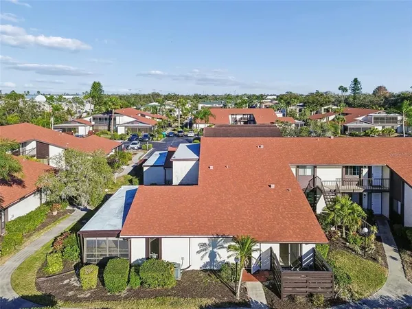 an aerial view of residential houses with outdoor space and ocean view