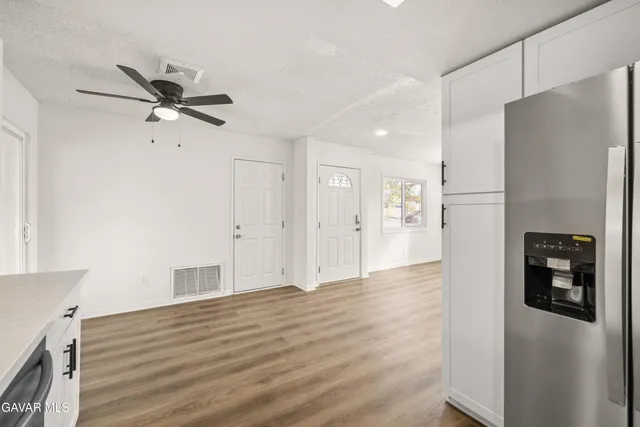a view of a kitchen with refrigerator and a stove top oven