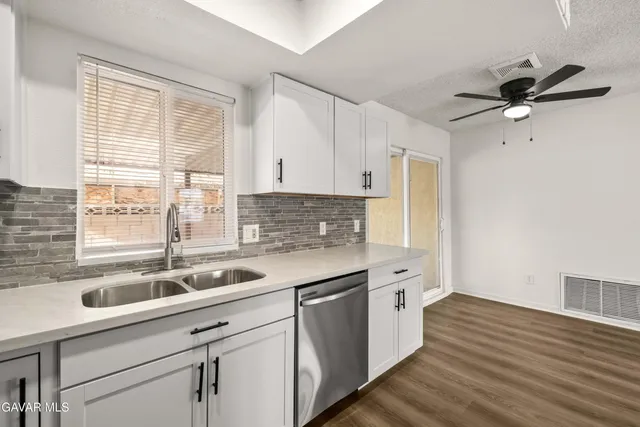 a kitchen with a sink cabinets appliances and a window
