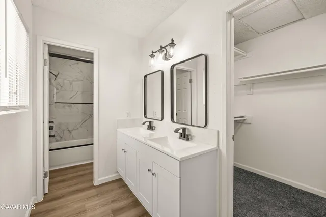 a bathroom with a sink a mirror and a shower