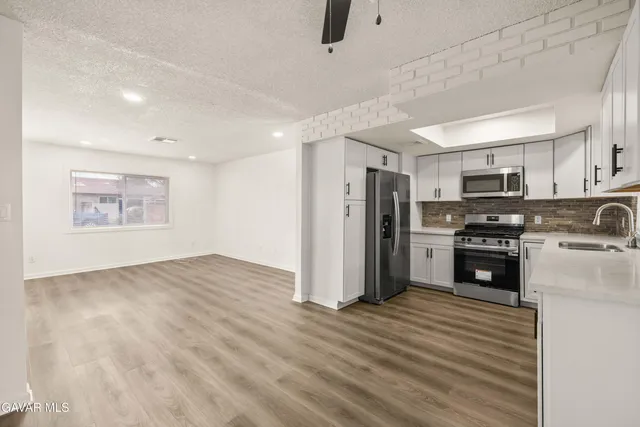 a kitchen with stainless steel appliances a refrigerator and a stove top oven