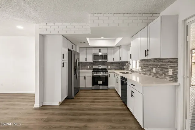 a kitchen with stainless steel appliances granite countertop a stove a sink and a refrigerator