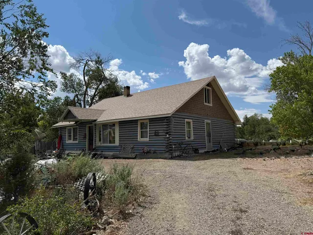 a view of house with a yard and potted plants