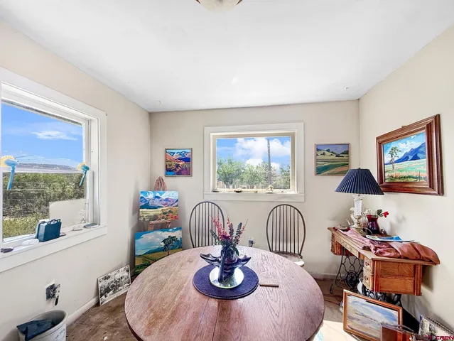 a dining room with furniture and a large window