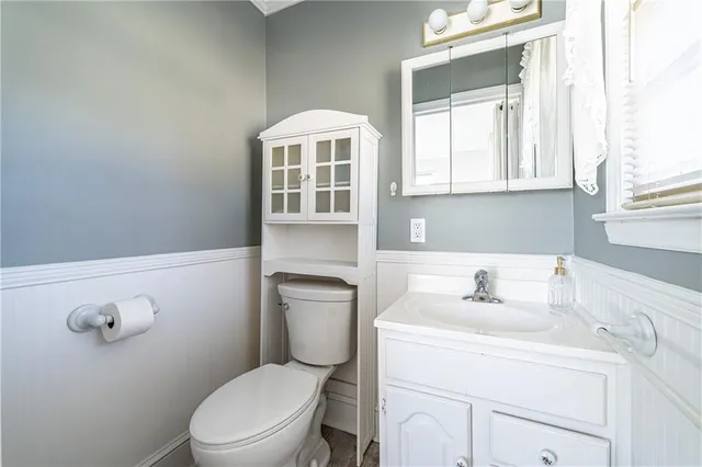 a bathroom with a sink a toilet and a window