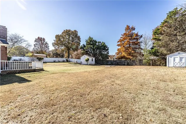 a view of a yard with wooden fence