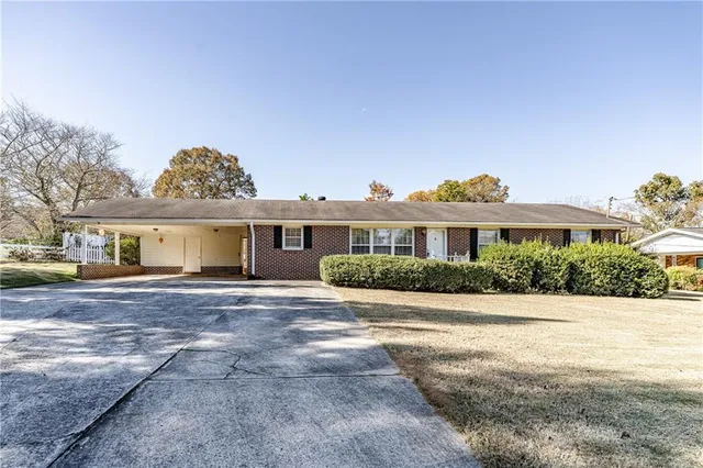 a front view of a house with a yard and potted plants