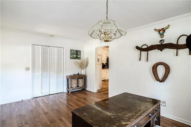 a view of a hallway with wooden floor and chandelier