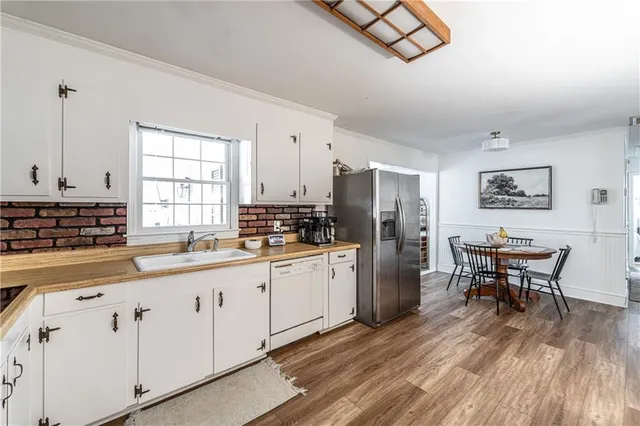 a kitchen with granite countertop white cabinets and stainless steel appliances