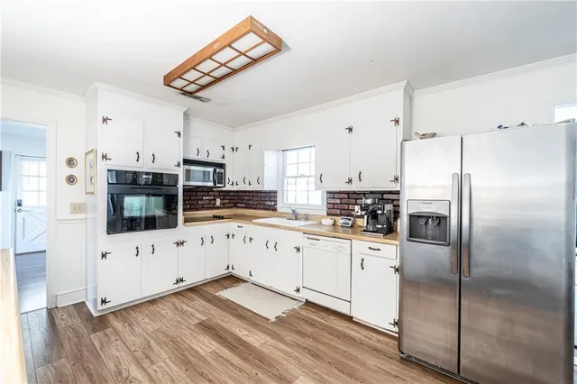 a kitchen with granite countertop a refrigerator and a stove top oven