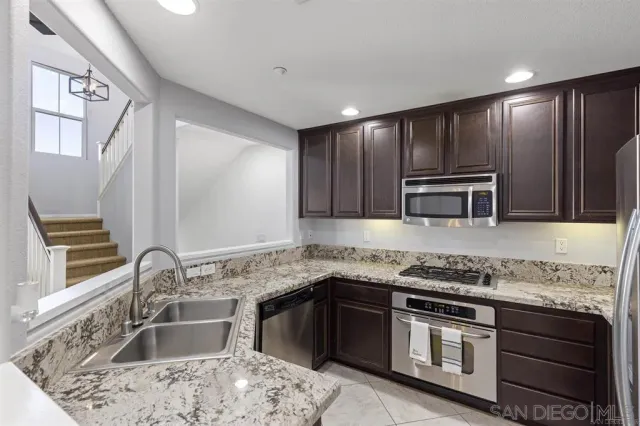 a kitchen with stainless steel appliances granite countertop a sink and stove