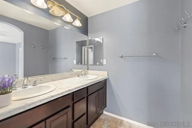 a bathroom with a granite countertop sink a large mirror and vanity