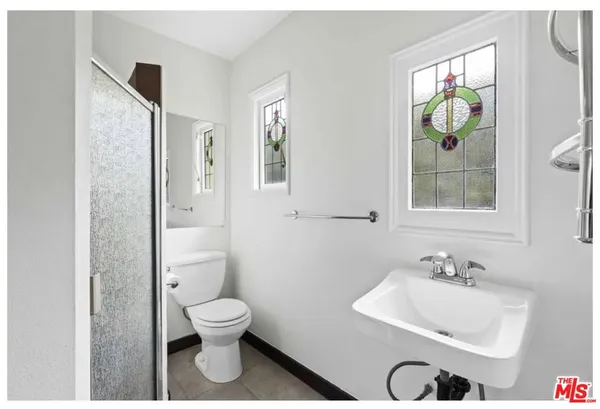 a bathroom with a toilet a sink and mirror