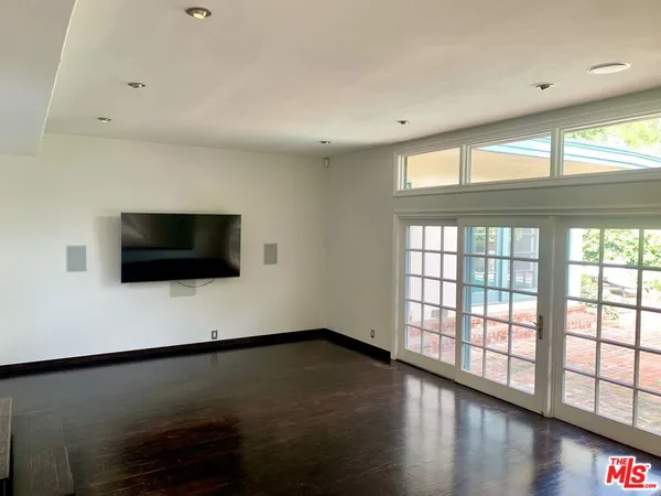 a view of a livingroom with wooden floor and a large window