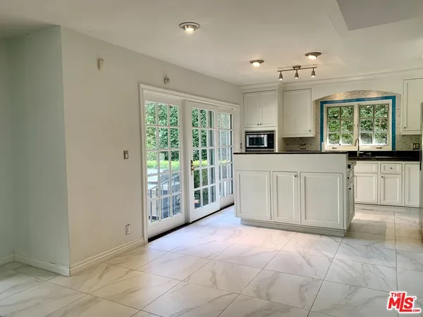 a large white kitchen with a large window