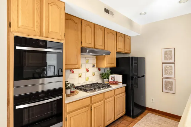 a kitchen with stainless steel appliances granite countertop a stove microwave and refrigerator