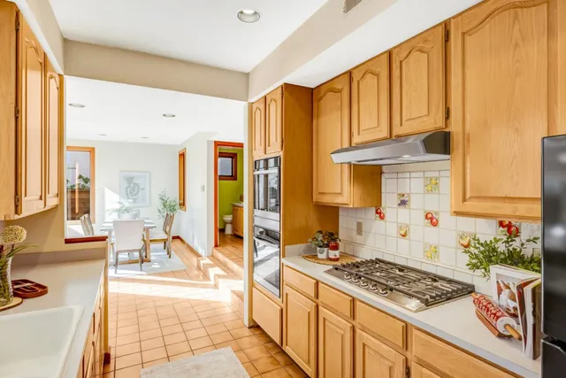 a kitchen with stainless steel appliances granite countertop a stove a sink and a refrigerator