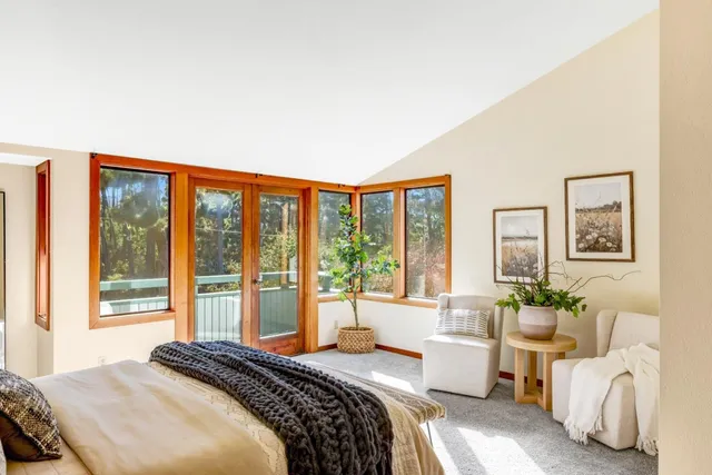 a bedroom with a bed and a large window