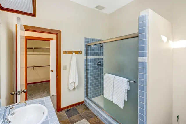 a bathroom with a sink and glass door shower