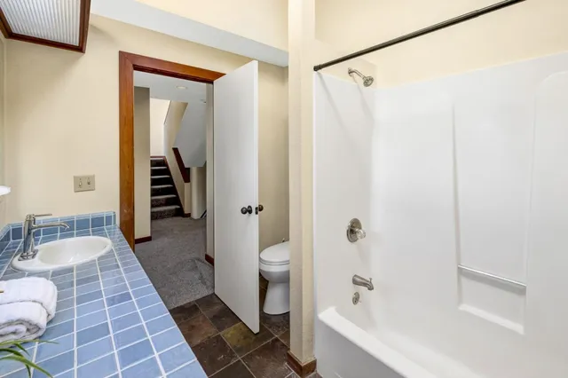 a bathroom with a sink a toilet and shower