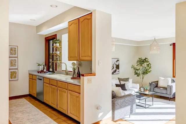 a living room with kitchen island furniture a sink and a window