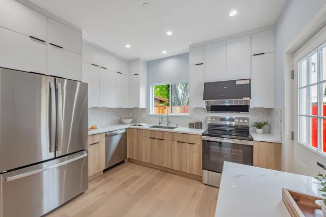 a kitchen with stainless steel appliances granite countertop a refrigerator stove microwave and sink