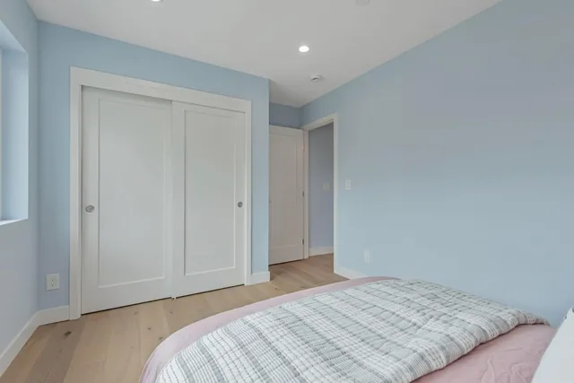 a bedroom with a bed and wooden floor