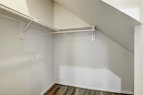 an empty room with wooden floor chandelier and ceiling fan