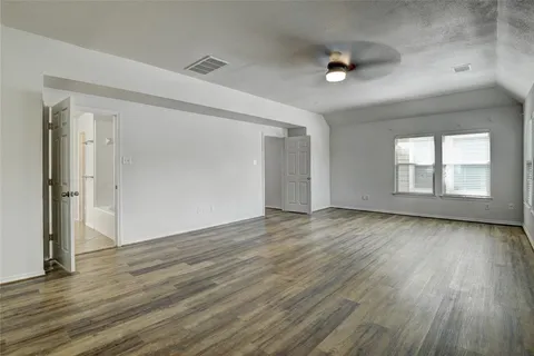an empty room with windows and fan