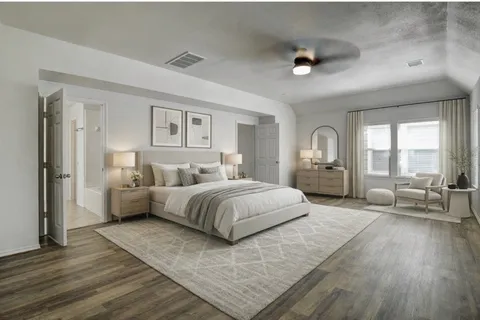 a spacious bedroom with a large bed and a wooden floor