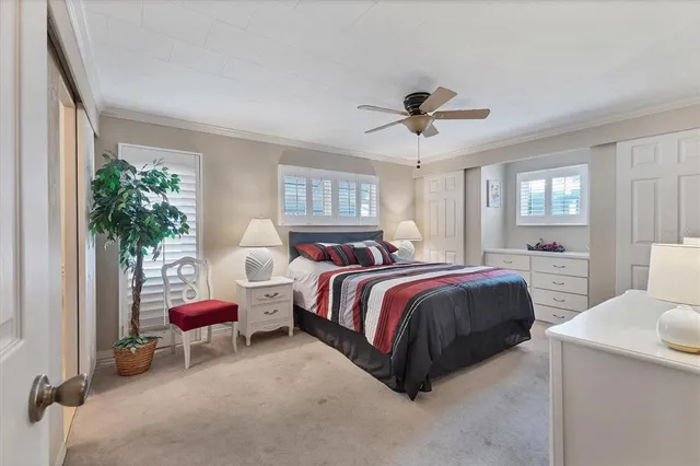 a spacious bedroom with a bed a chandelier and a window