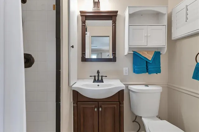 a bathroom with a toilet a sink and mirror
