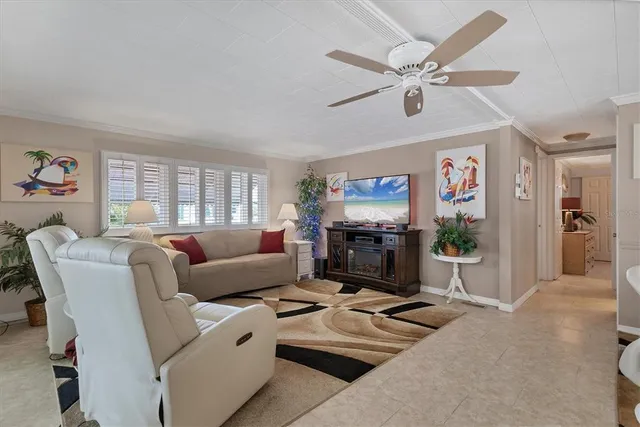 a living room with furniture a flat screen tv and a window