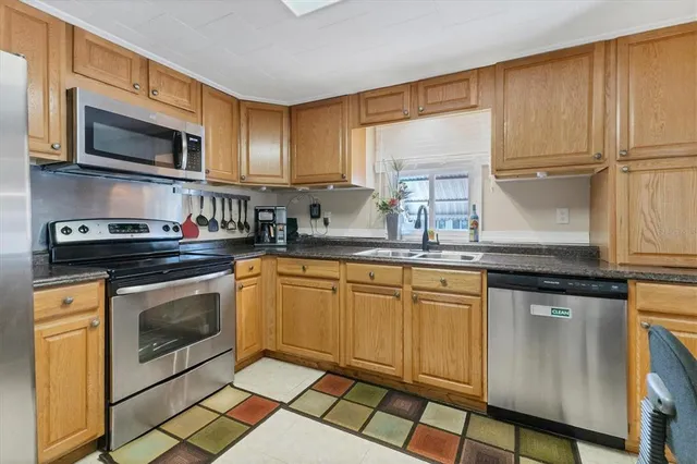 a kitchen with stainless steel appliances granite countertop a stove a sink and a microwave