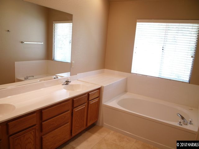 3938 Aspendale Drive Reno, NV 89503 - Photo 8 of 9 a bathroom with a tub sink and mirror