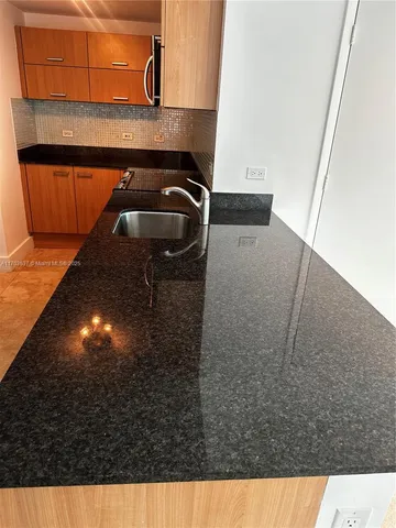 a kitchen with stainless steel appliances granite countertop a sink and a refrigerator