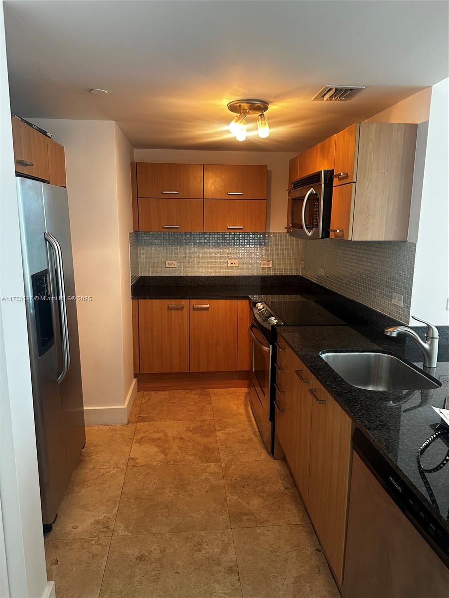 350 South Miami Avenue, Unit 1704 Miami, FL 33130 - Photo 9 of 13 a kitchen with stainless steel appliances granite countertop a sink and a refrigerator